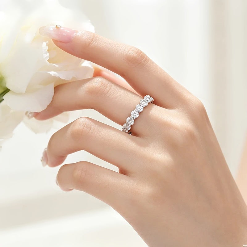Aliança eternidade de moissanite 5 mm usada na mão com flores