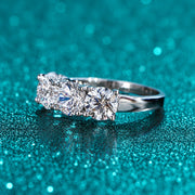Anel 5 Pedras de Moissanite 2,5 ct ou 5 ct em prata 925 sobre fundo verde com brilho