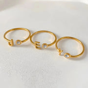 Anéis abertos com inicial J, E e Y dourados e pedra cristal