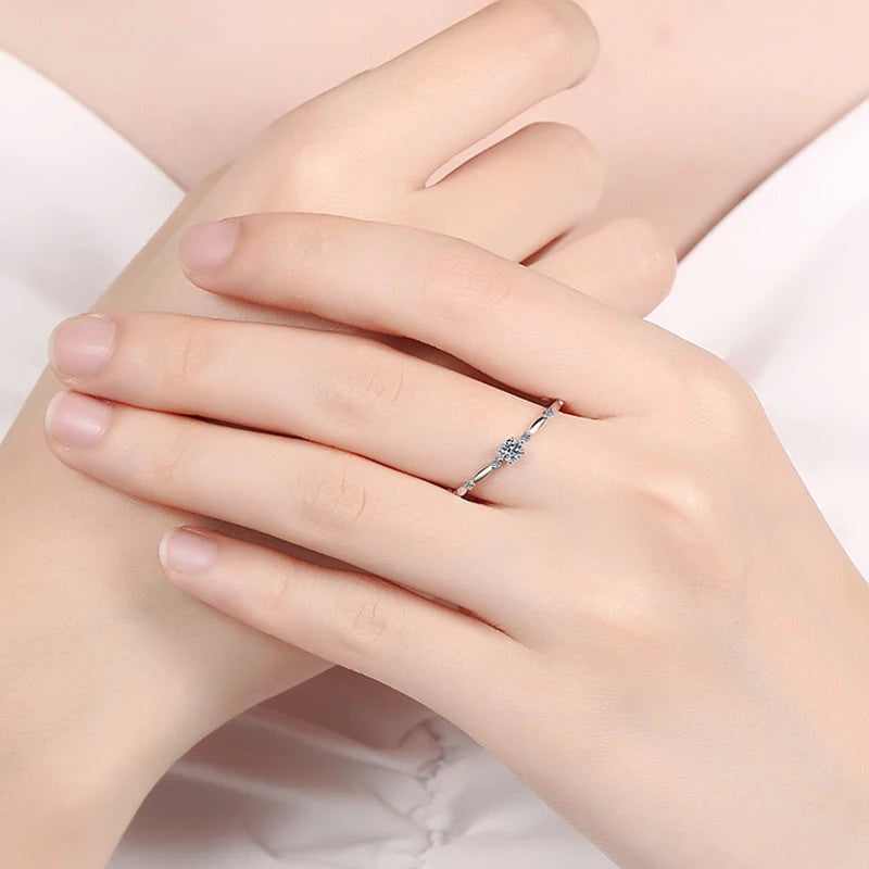 Anel delicado de moissanite em mãos cruzadas