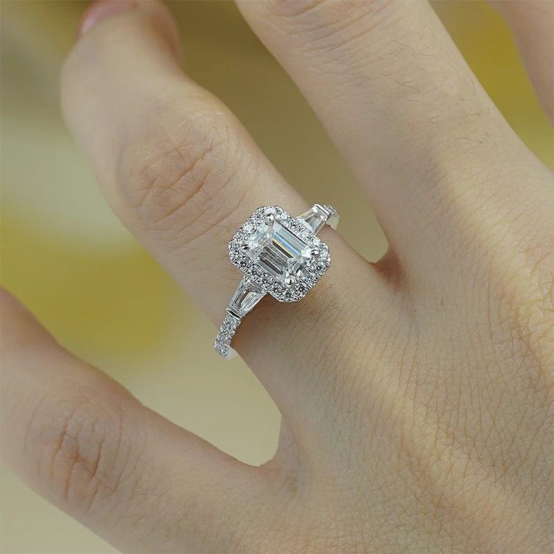 Anel halo de moissanite corte esmeralda usado na mão