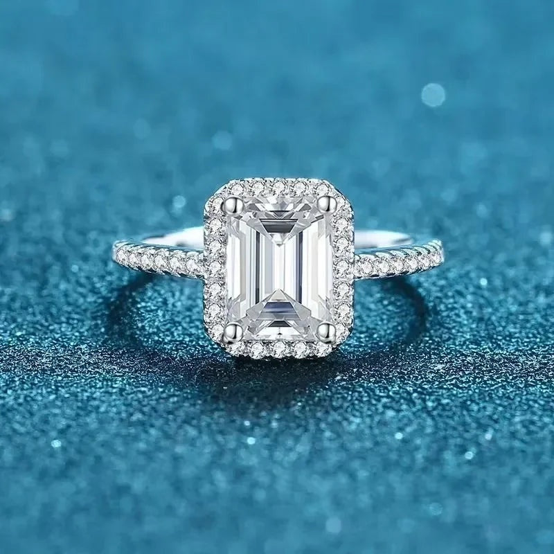 Anel halo retangular de moissanite corte esmeralda visto de frente