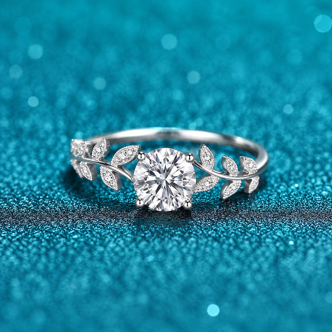 Anel de Moissanite 1ct com Folhas Cravejadas em prata 925 sobre fundo verde com brilho