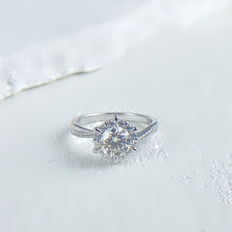 Anel de moissanite halo floral visto de lado sobre superfície clara