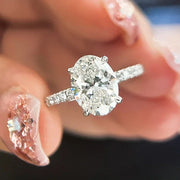 Anel de noivado oval de moissanite segurado entre os dedos