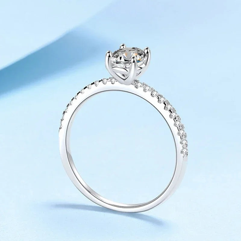 Anel de noivado oval de moissanite em pé mostrando a garra