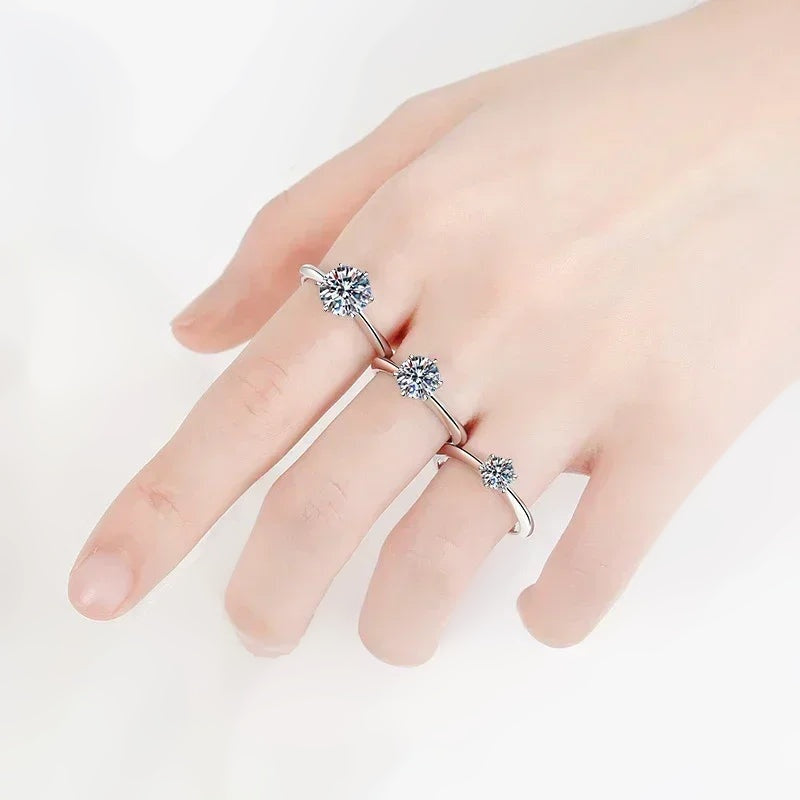 Mão com solitários de moissanite de três tamanhos