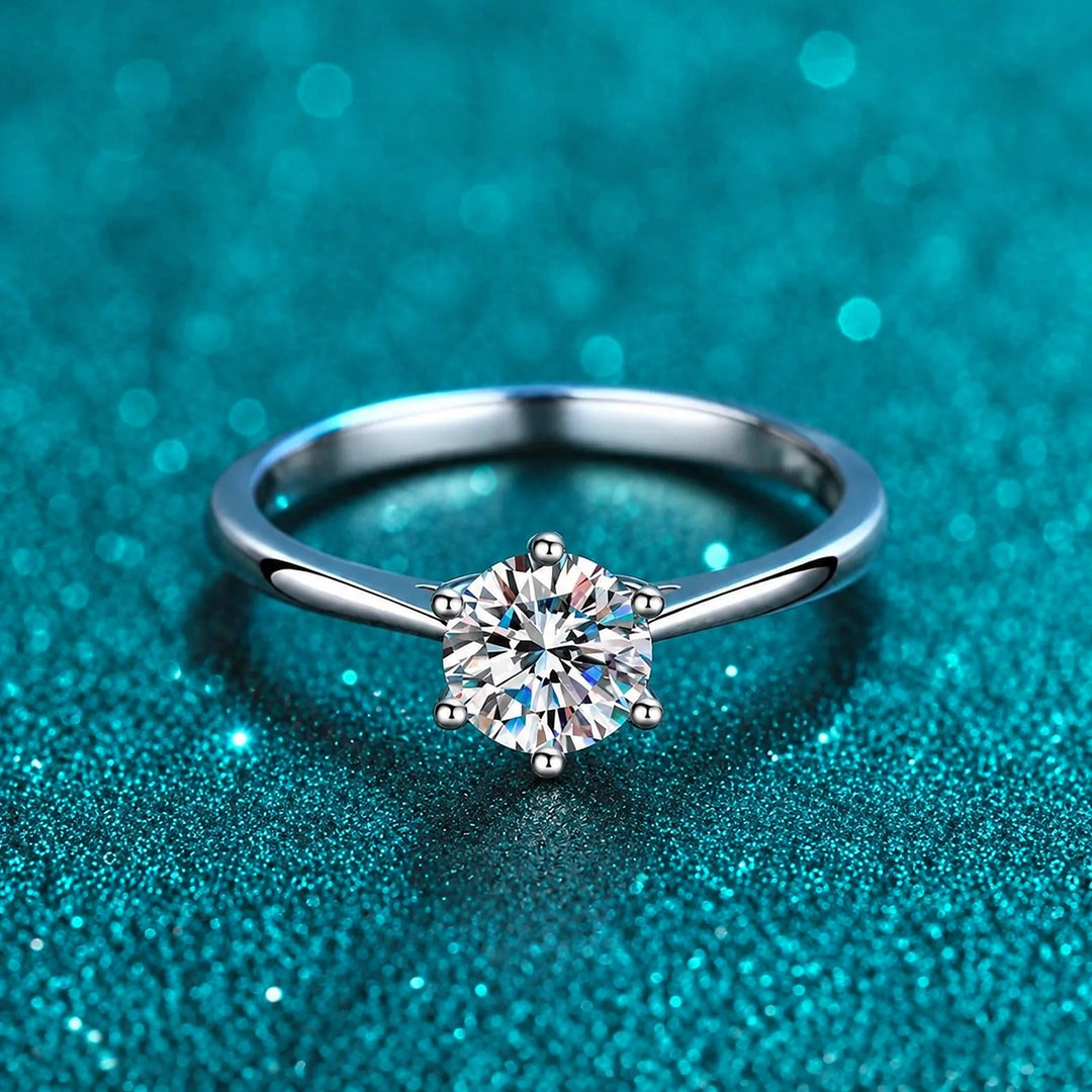 Anel Solitário Delicado de Moissanite 0,3 ct 6 Garras em prata 925 sobre fundo verde com brilho