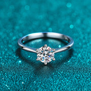 Anel Solitário Delicado de Moissanite 0,3 ct 6 Garras em prata 925 sobre fundo verde com brilho