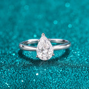 Anel Solitário Gota de Moissanite 2ct em prata 925 sobre fundo verde com brilho