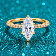 Anel Solitário Marquise de Moissanite Dourado em prata 925 sobre fundo verde com brilho