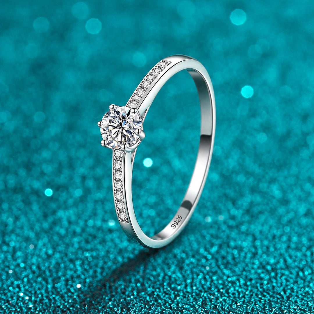 Anel Solitário de Moissanite 0,3 ct com Aro Cravejado em prata 925 sobre fundo verde com brilho