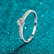 Anel Solitário de Moissanite 0,3 ct com Aro Cravejado em prata 925 sobre fundo verde com brilho