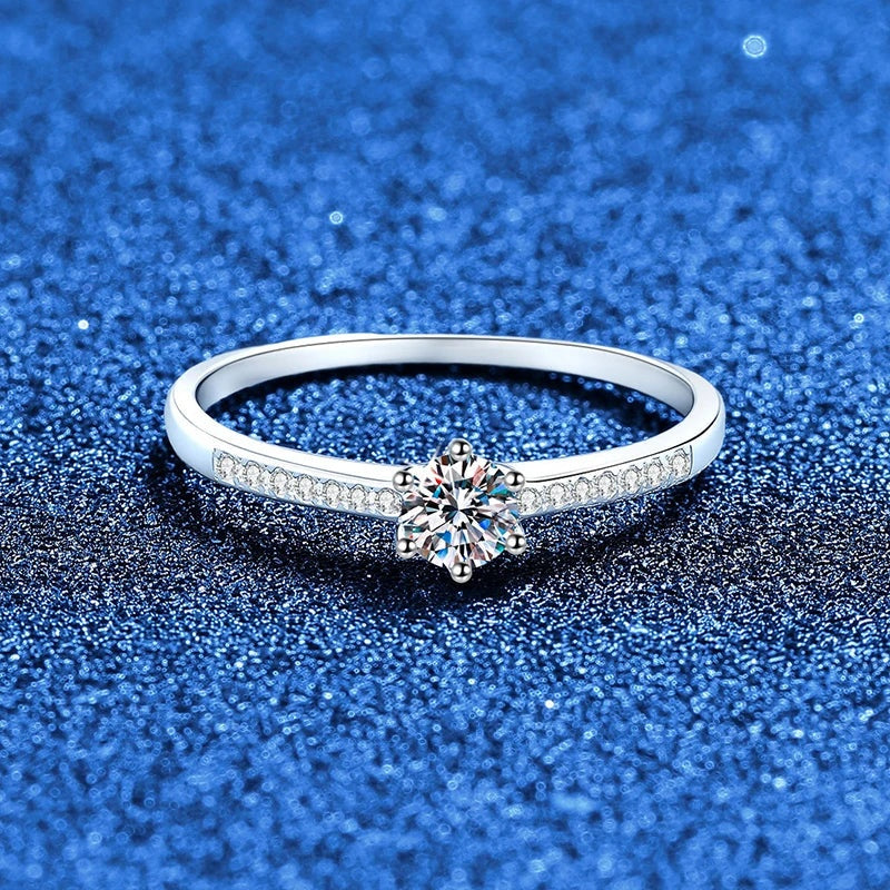 Anel solitário de moissanite 0,3 ct visto de frente em fundo azul