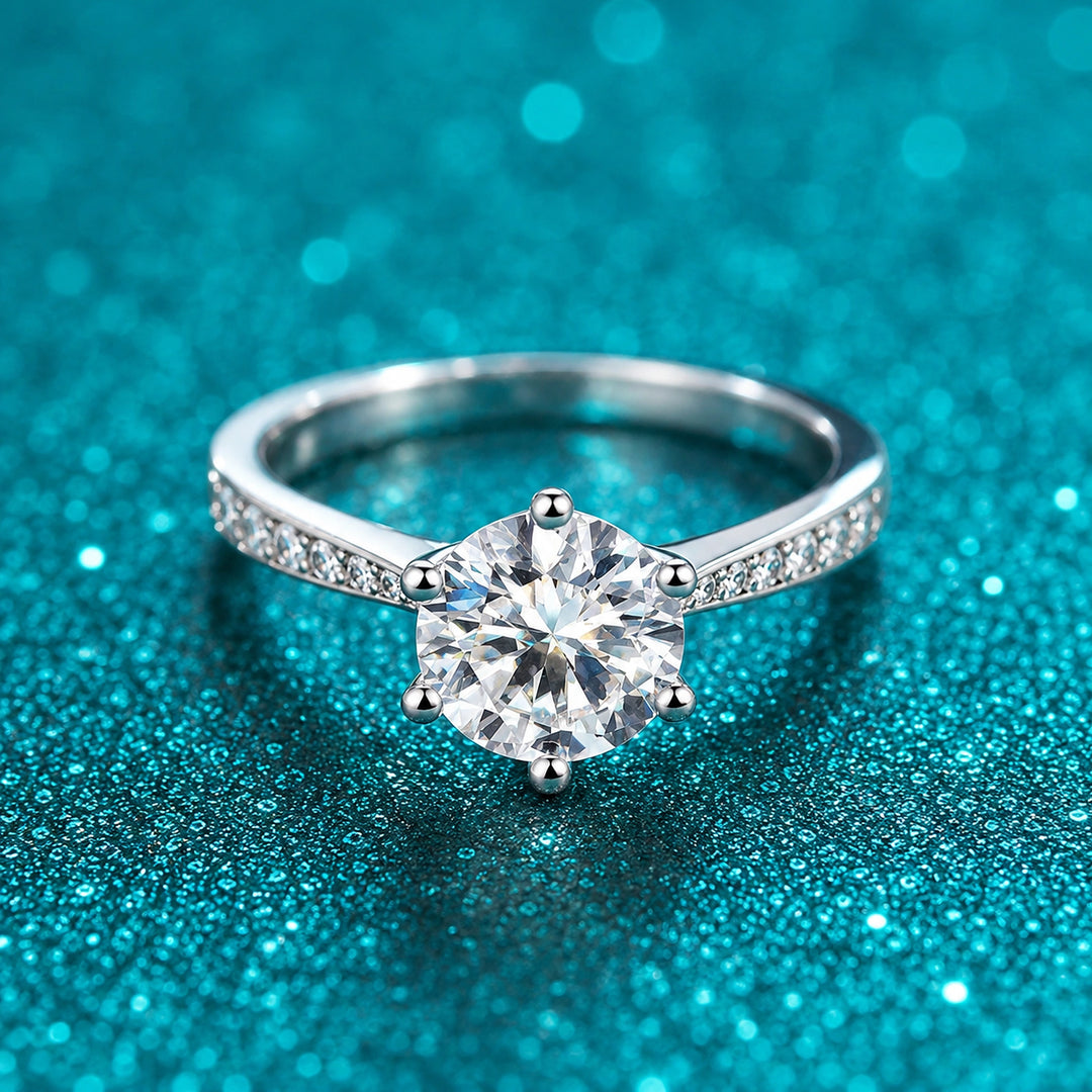 Anel Solitário de Moissanite 6 Garras com Aro Cravejado em prata 925 sobre fundo verde com brilho