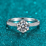 Anel Solitário de Moissanite Colorida 1ct Cravejado em prata 925 sobre fundo verde com brilho