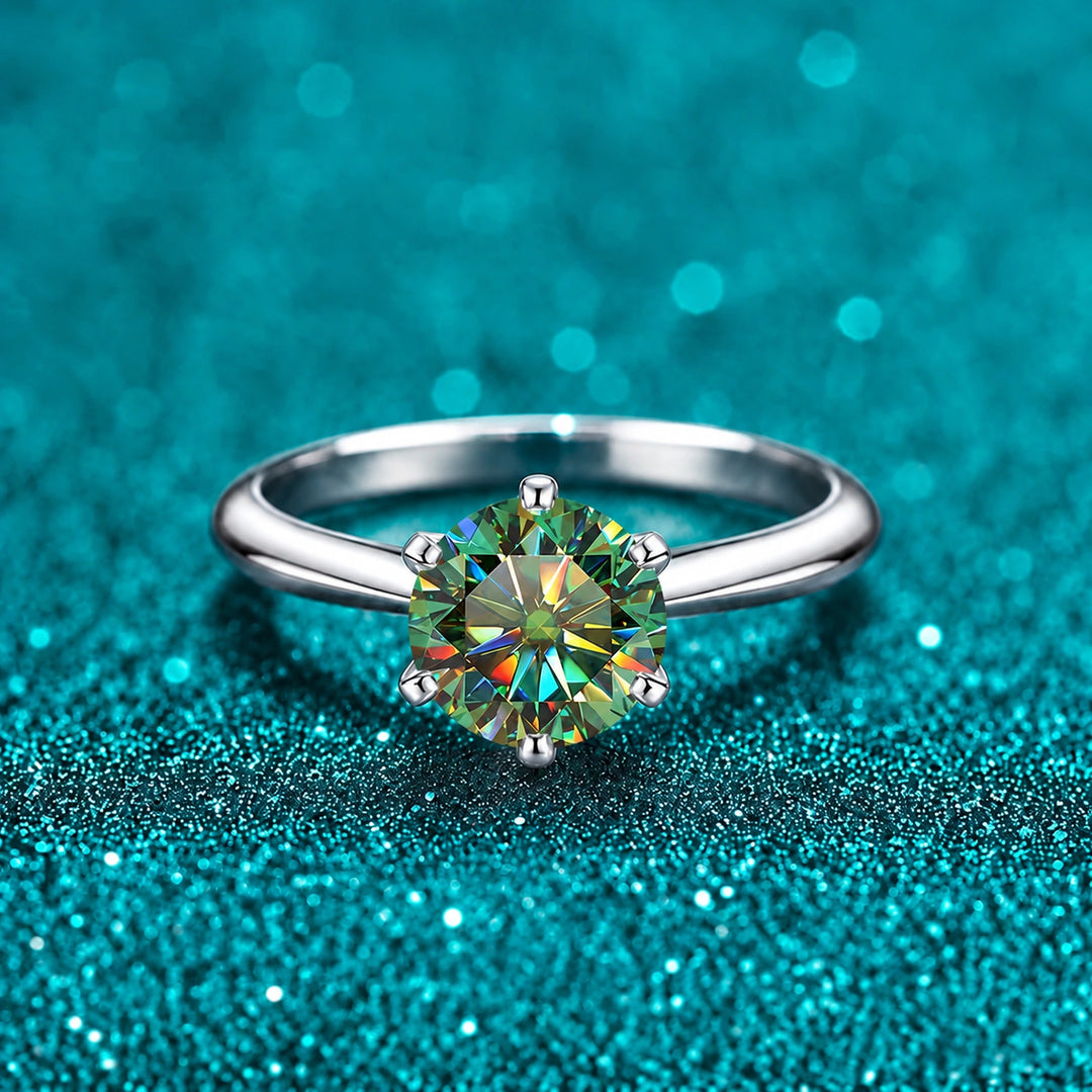 Anel Solitário de Moissanite Colorida com Aro Liso cor da pedra verde em prata 925 sobre fundo verde