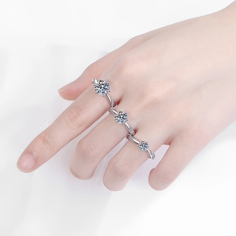Mão com três anéis solitários de moissanite em tamanhos diferentes