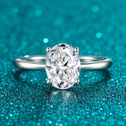 Anel Solitário Oval de Moissanite 2ct Aro Liso em prata 925 sobre fundo verde com brilho