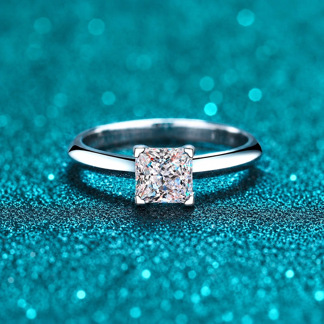 Anel Solitário Princesa de Moissanite 1ct ou 2ct em prata 925 sobre fundo verde com brilho