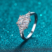 Anel Três Pedras de Moissanite 3ct em prata 925 sobre fundo verde com brilho