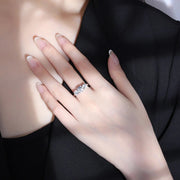 Anel três pedras de moissanite usado na mão sobre roupa preta