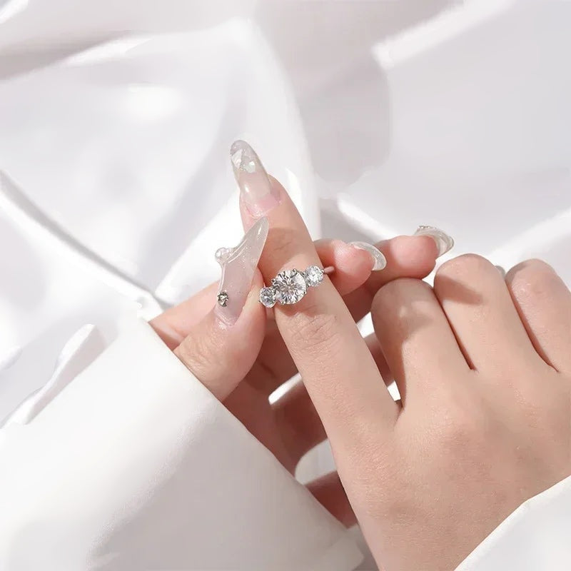 Anel três pedras de moissanite segurado com unhas decoradas