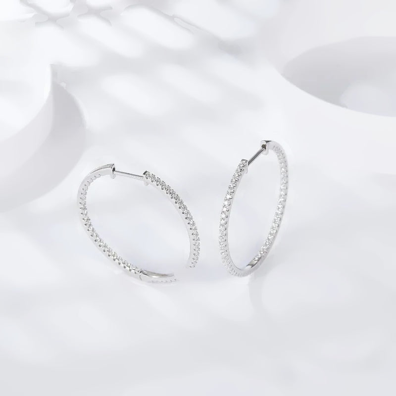 Par de argolas cravejadas de moissanite sobre fundo claro