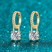 Brinco Argola Cravejada com Pingente de Moissanite 1 ct em prata 925 sobre fundo verde com brilho