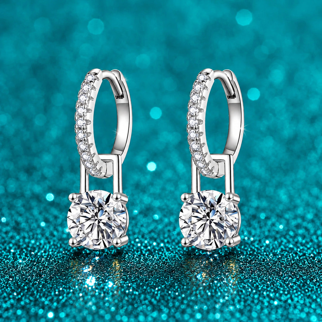 Brinco Argola Cravejada com Pingente de Moissanite 1 ct cor ouro branco em prata 925 sobre fundo verde