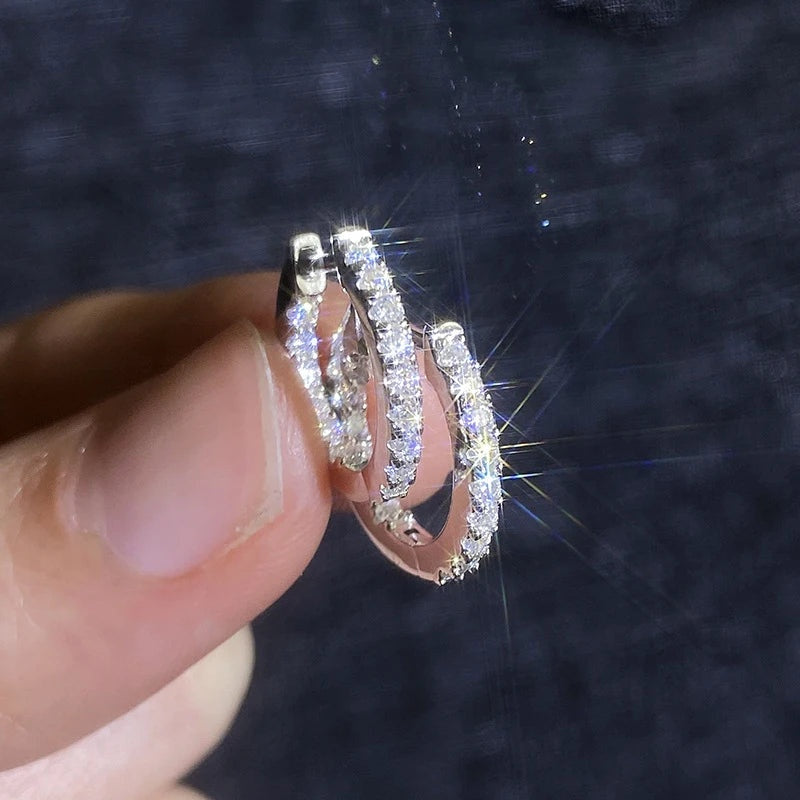 Mão segurando argolinha cravejada de moissanite