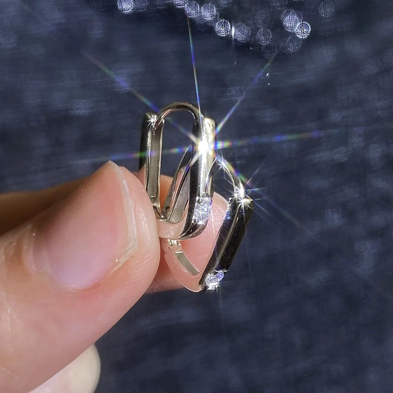 Mão segurando argolinha retangular com moissanite
