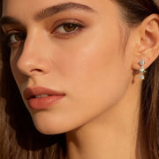 Mulher usando brinco pendente de três moissanites