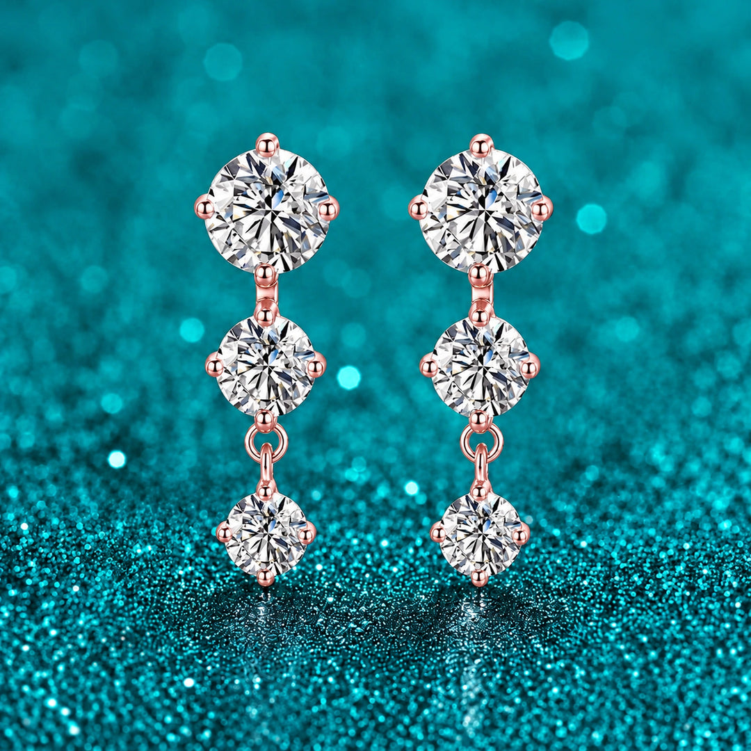 Brinco Pendente Três Moissanites Degradê cor ouro rosé em prata 925 sobre fundo verde