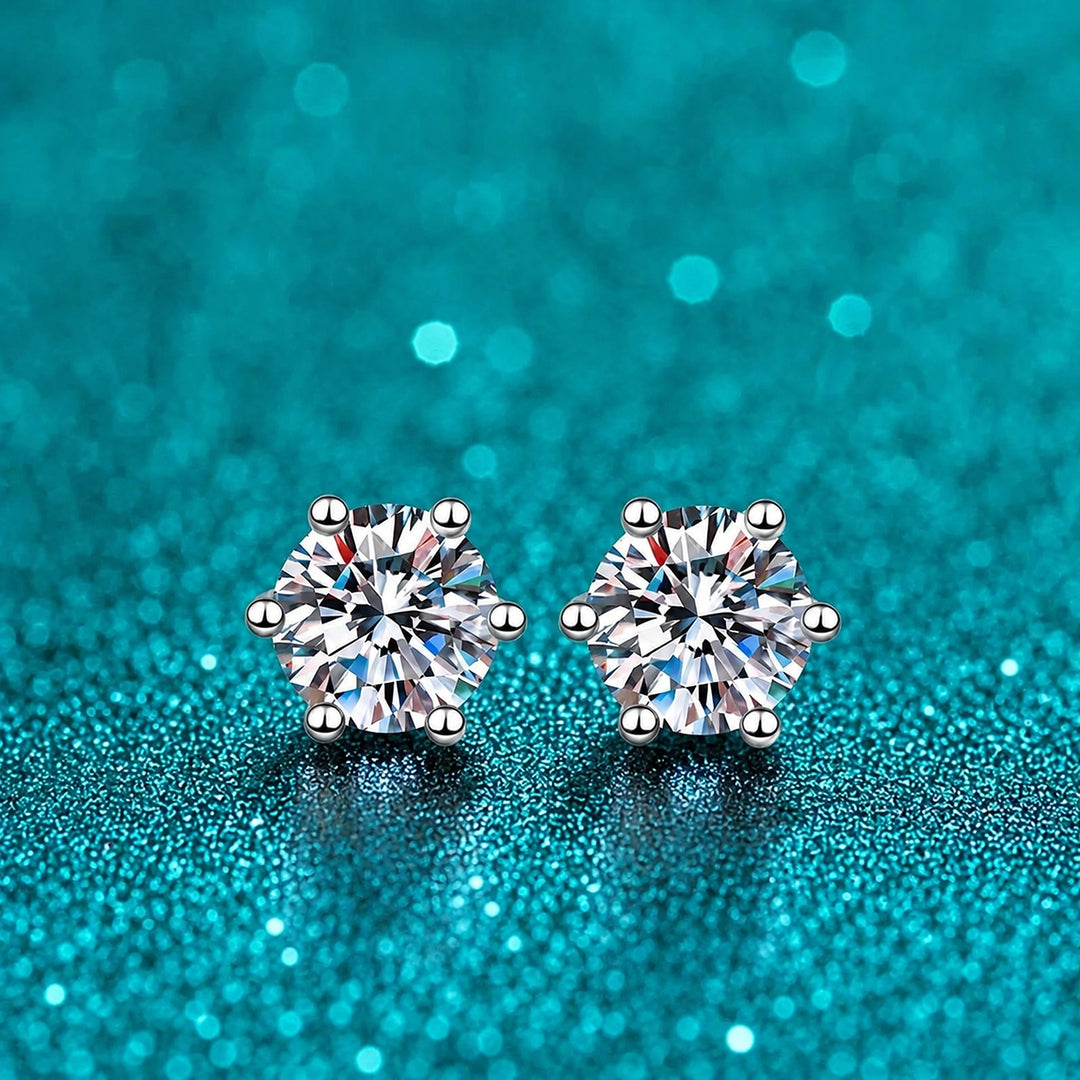 Brinco Ponto de Luz Seis Garras de Moissanite em prata 925 sobre fundo verde com brilho