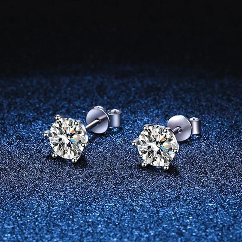Par de brincos ponto de luz de moissanite sobre fundo azul brilhante