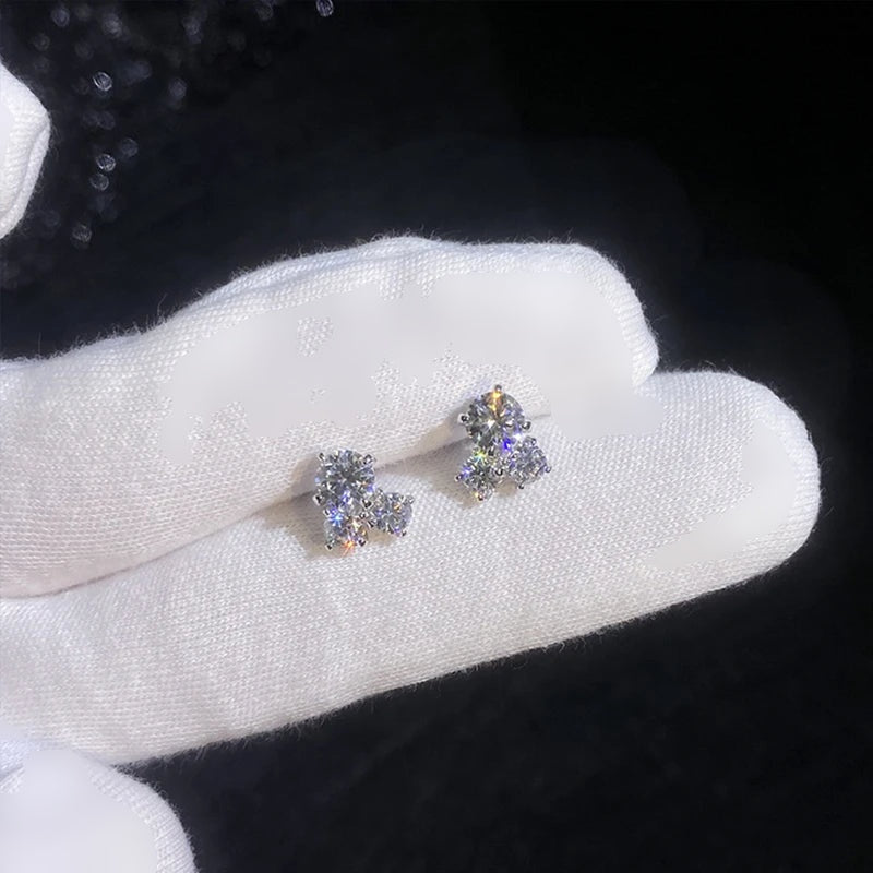 Brincos trevo de moissanite apoiados em luva branca