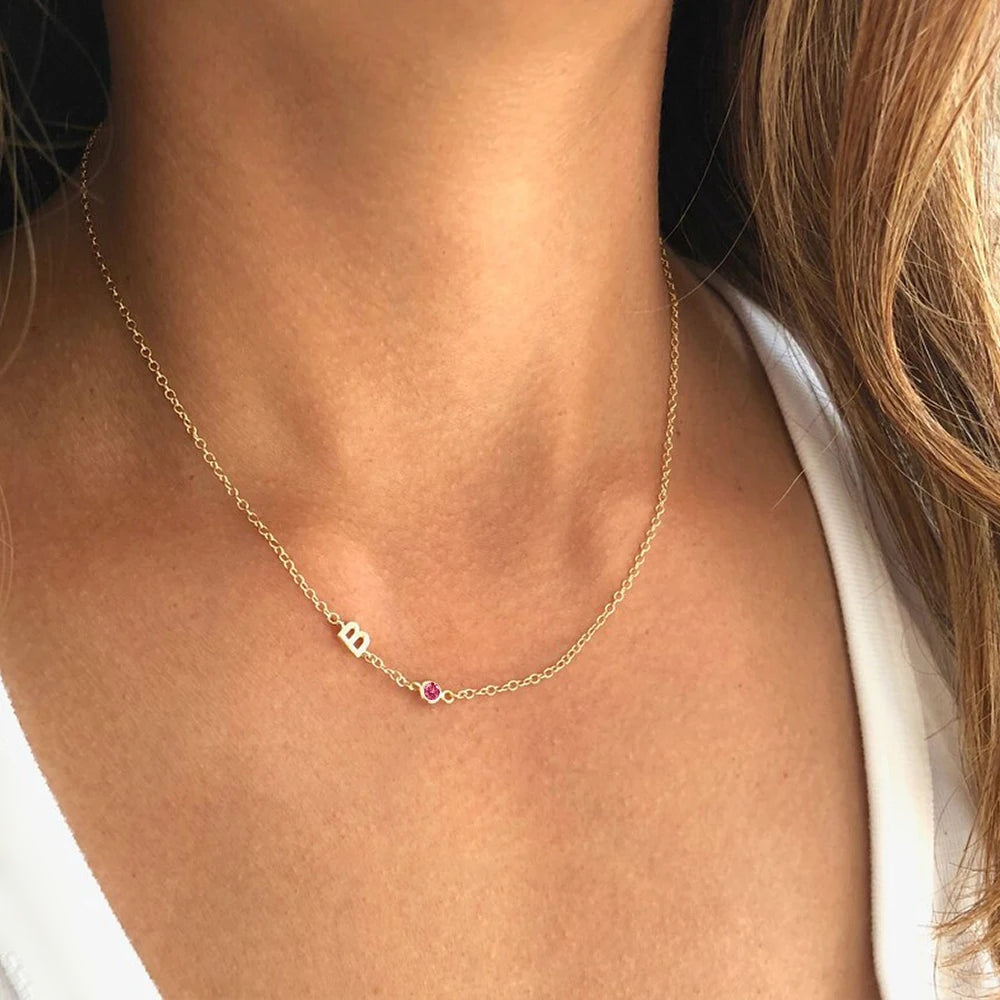 Colar com inicial e pedra do mês rosa dourado usado no pescoço