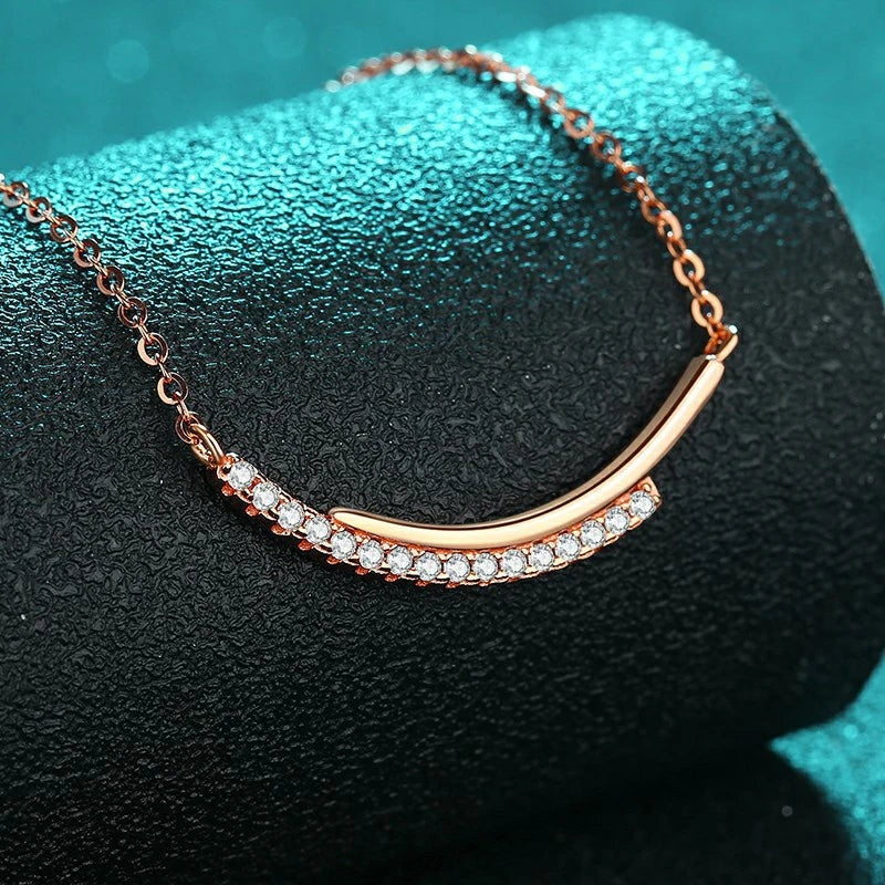Colar barra curva de moissanite ouro rosé apoiado em expositor