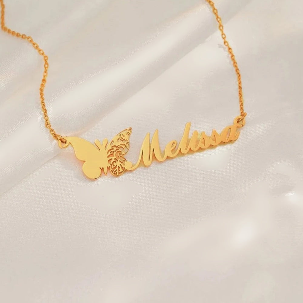 Colar com nome e borboleta dourado Melissa sobre tecido branco