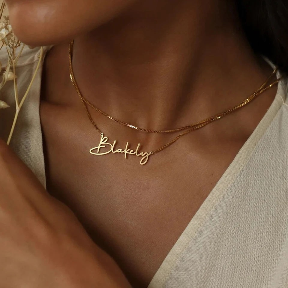 Colar com nome dourado em letra cursiva usado em camadas