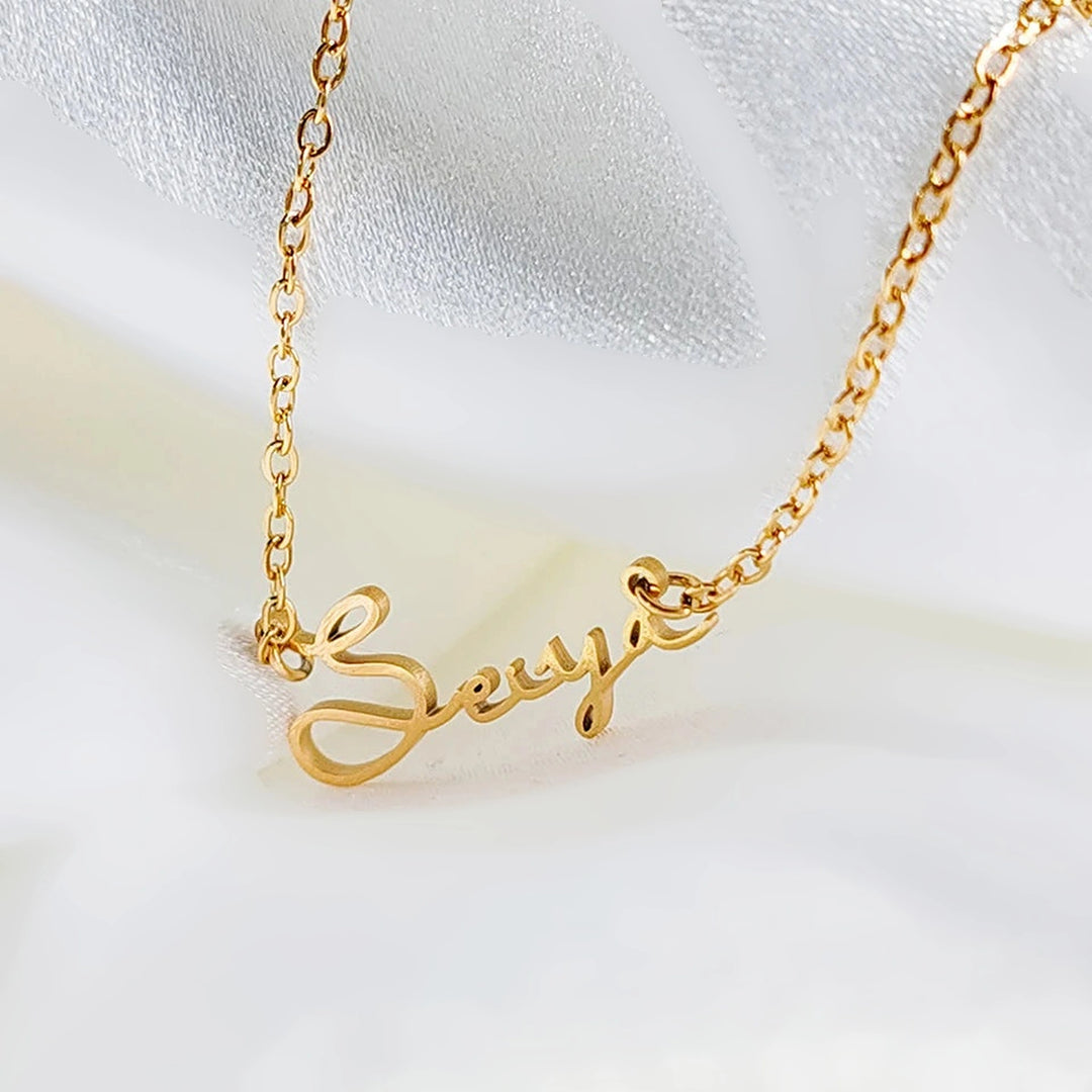 Colar com nome estilo assinatura dourado sobre tecido branco