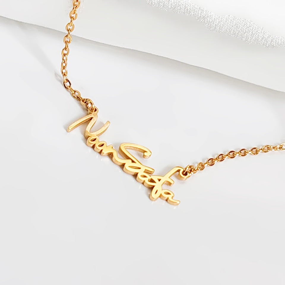 Colar com nome em letra de assinatura dourado visto de perto