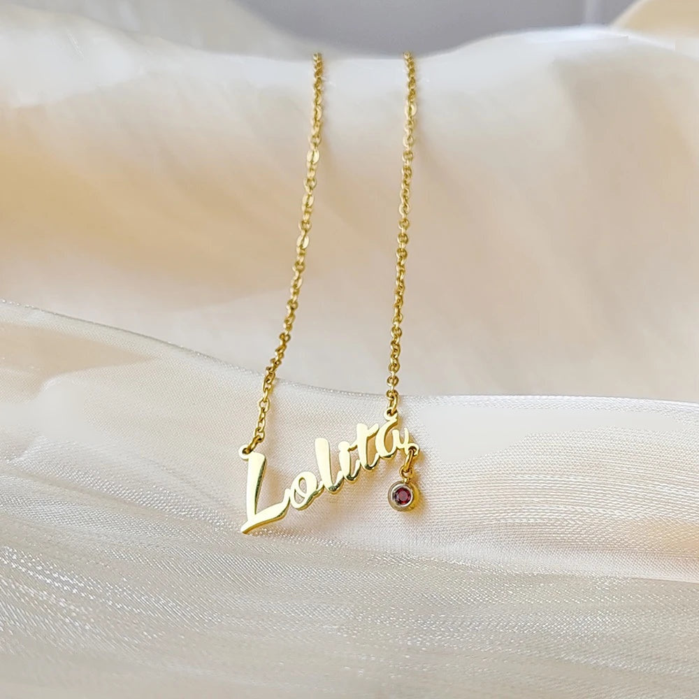 Colar com nome Lolita dourado com pedrinha pendurada sobre tecido