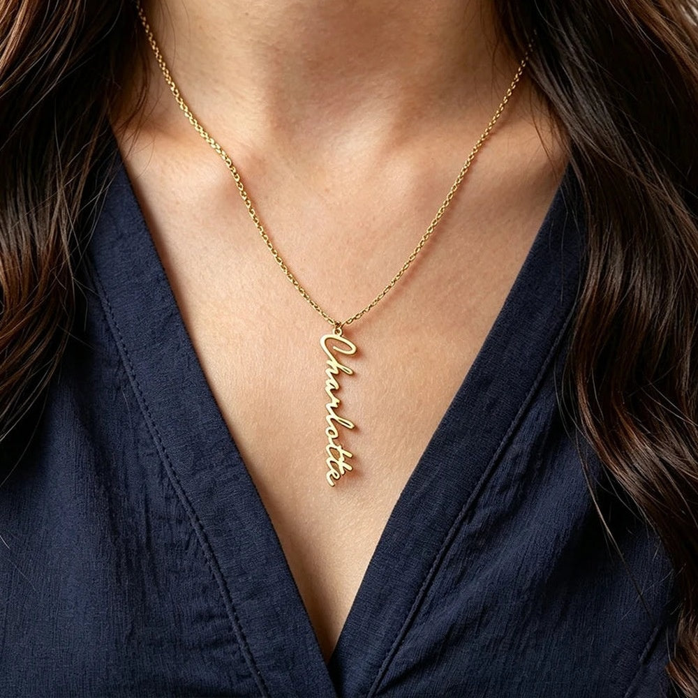 Colar com nome na vertical dourado usado com blusa azul marinho