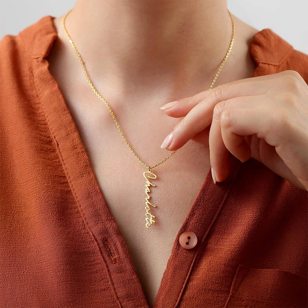 Colar com nome vertical dourado usado com camisa laranja