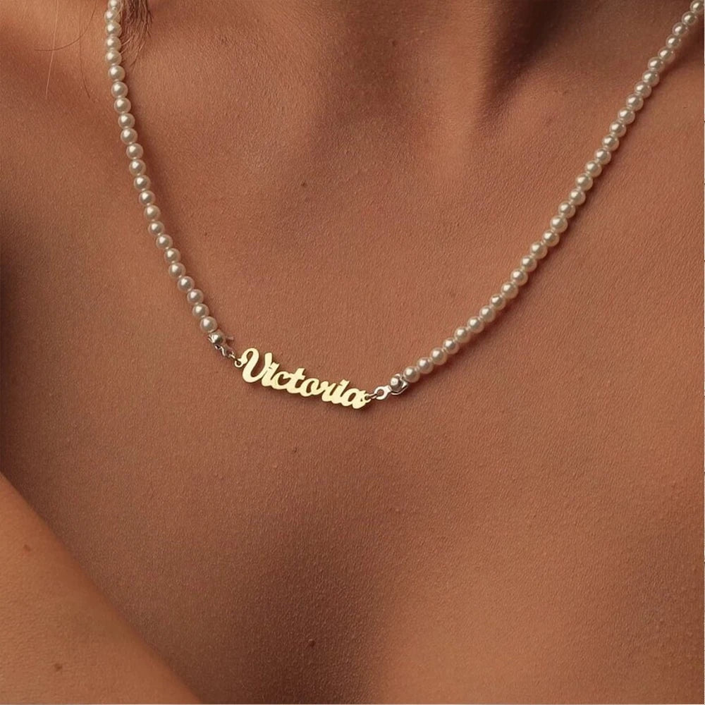 Colar de pérolas com nome Victoria dourado no pescoço