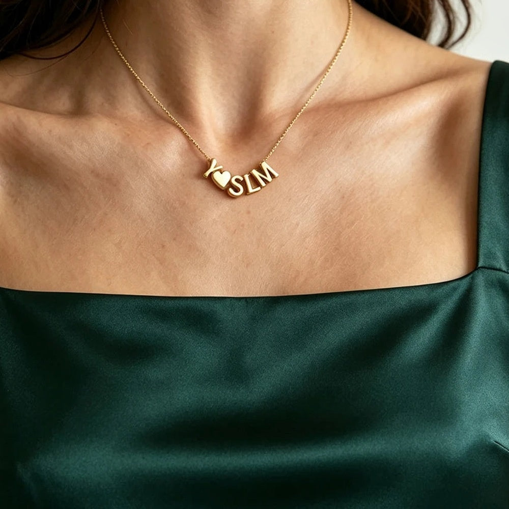 Colar com iniciais e coração dourado usado com blusa verde