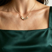 Colar com iniciais e coração dourado usado com blusa verde