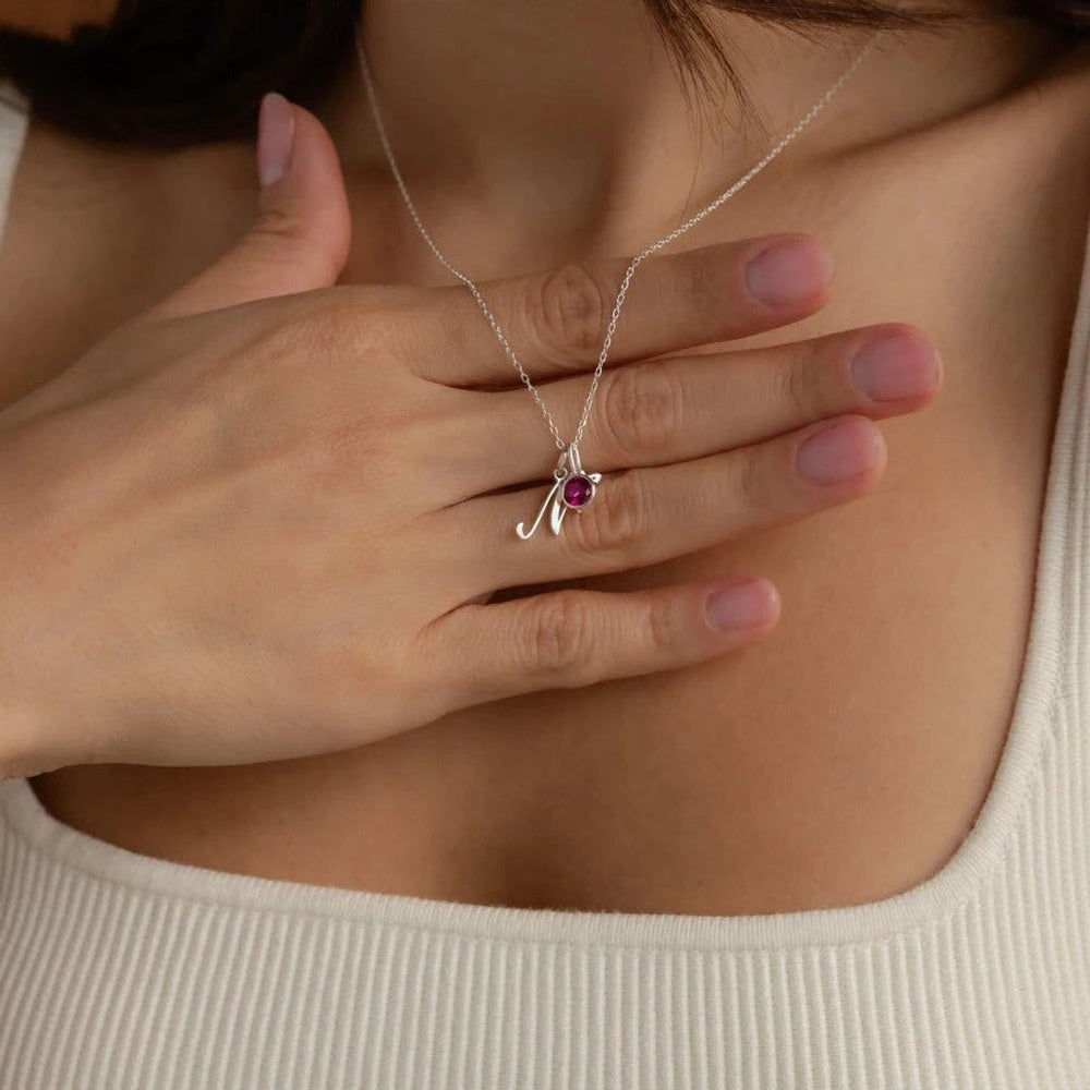 Colar com inicial N prata e pedra do mês roxa usado com blusa branca